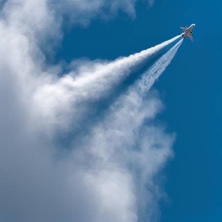 Airplane Contrail in Blue Sky High Altitude Ice Crystal Cloud Created by Jet Exhaust