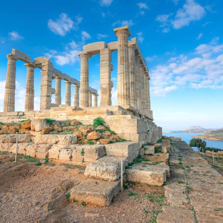 Ancient Temple of Poseidon at Cape Sounion with Summer Sailboats