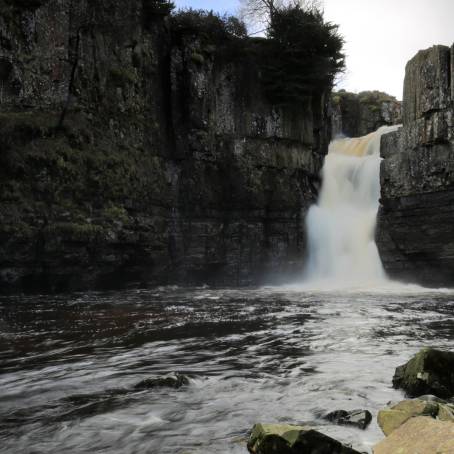 Awe inspiring High Force waterfall cascading down rugged cliffs