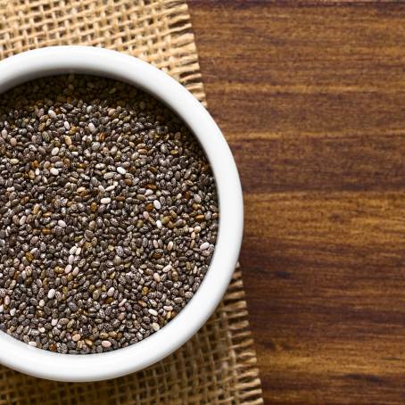 Chia Seeds in a Wooden Spoon with Essential Vitamins on a Smooth Countertop