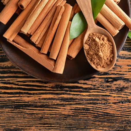 Cinnamon Sticks with Powder on White Background