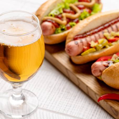 Classic Hot Dog with Mustard, Ketchup, and Beer on Table