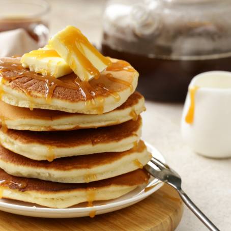 Classic Pancakes with Syrup and Butter on White Background