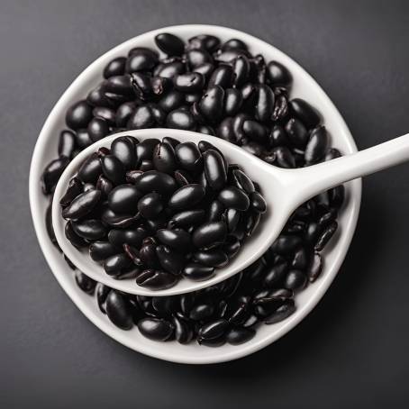 Close Up of Black Beans in White Ceramic Spoon on Black Background Isolated Food Shot