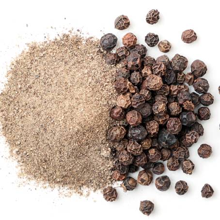 Close Up of Peppercorns and Ground Pepper in Wooden Bowl