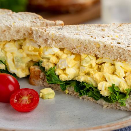 Close Up of Soft Boiled Eggs with Dill on Whole Grain Toast, Healthy Breakfast on White Plate