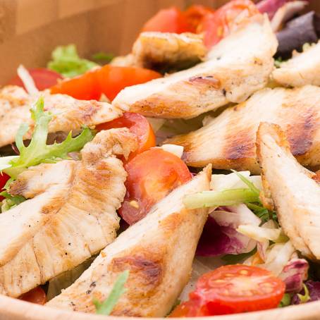 Closeup of Chicken Salad with Fresh Tomatoes and Greens