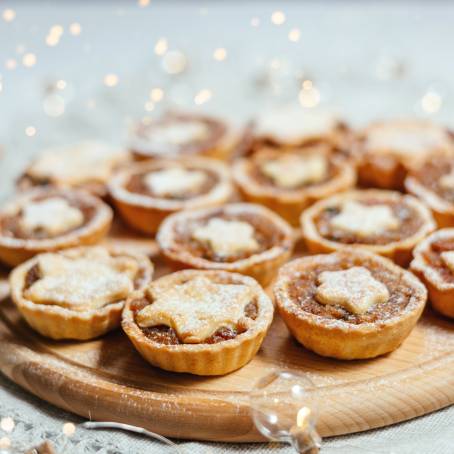 Closeup of Open Mince Pie with Festive Red Background and Wooden Table