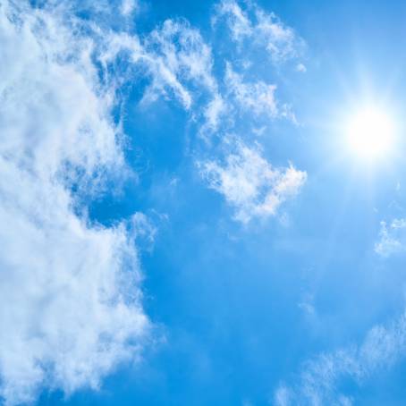 Cloudscape and Blue Sky Sunlit Nature Background with Shining Sun and Clouds