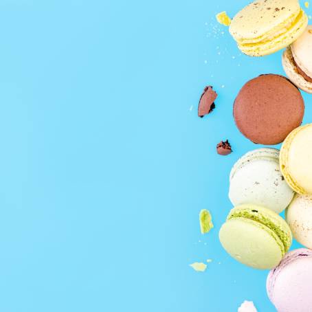 Colorful French Macarons Flying in Freeze Motion with Blue Background