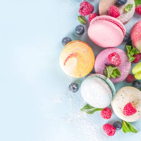 Colorful French Macarons in Freeze Motion Floating Over Blue Backdrop