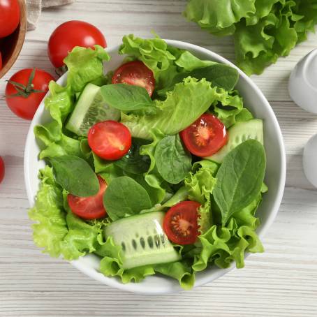 Colorful Salad with Spinach, Cherry Tomatoes, Lettuce, Cucumber and More Isolated on White