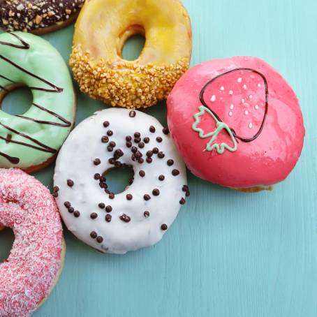 Colorful Strawberry Glazed Donuts with Sprinkles on Pure White Background