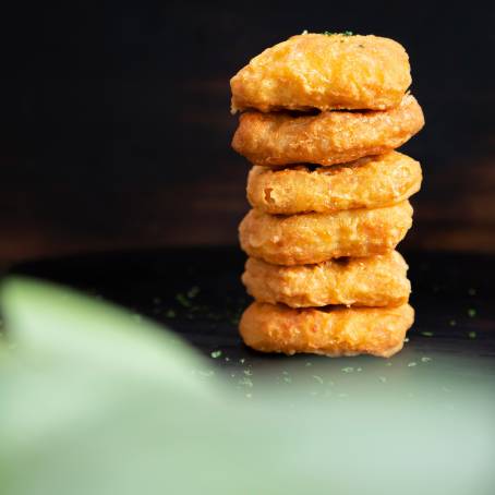 Crispy Nuggets Falling on a White Plate