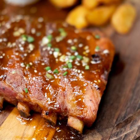 Delectable Smoked Ribs with Spicy Barbecue Glaze on a Carving Board