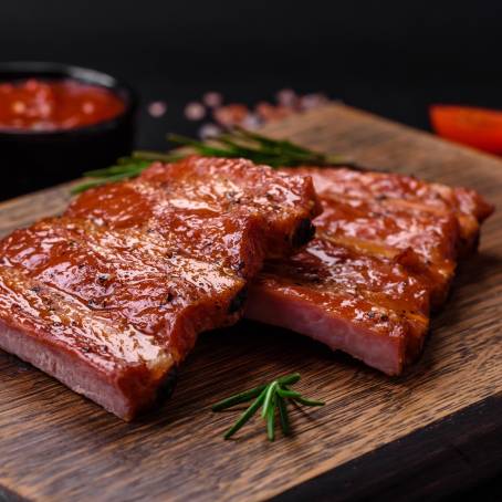 Delicious Grilled Ribs with Tangy Barbecue Sauce on a Carving Board