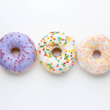 Delicious Strawberry Glazed Donuts with Sprinkles on a White Background