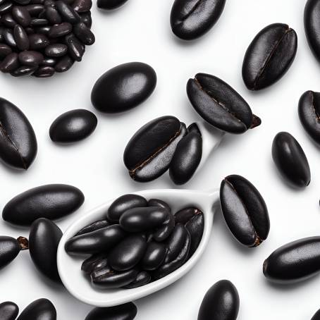 Detailed Close Up of Black Beans in White Ceramic Spoon on Black Background Isolated Food Shot