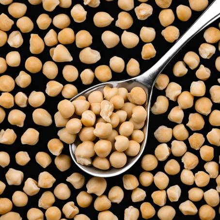 Detailed Close Up of Chickpeas in White Ceramic Spoon on Black Background Isolated Food Shot