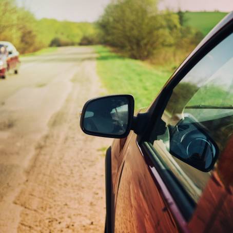 Driving Through Europe Red Car on Mountain Road with Sunny Nature Scenery