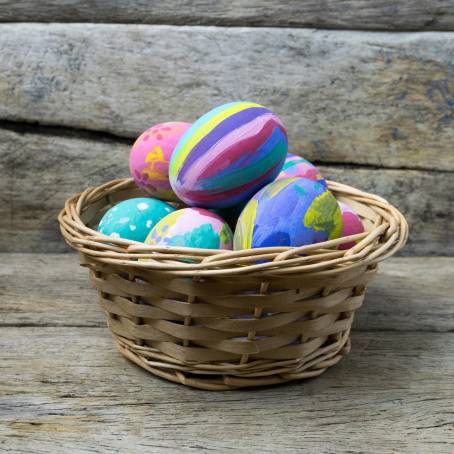 Easter Basket with Colorful Eggs on Wood