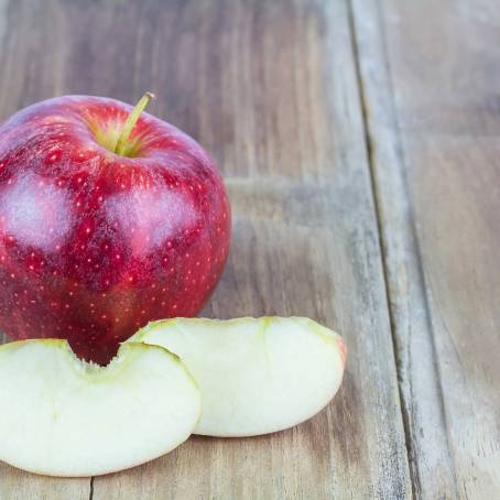 Elegant Red Apples and Slices in White Bowl on Black Background