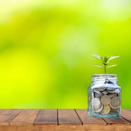 Financial Growth Concept Jar with Money and Coins Stack on Table for Savings Plan