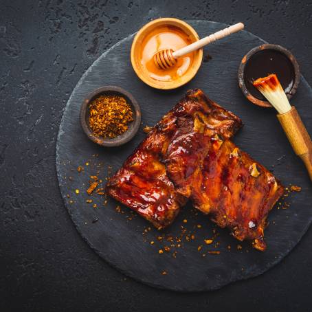 Flavorful Smoked Ribs with Robust Barbecue Sauce on a Carving Board