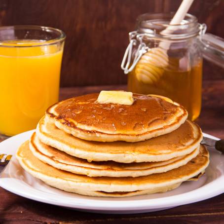 Fluffy American Pancakes with Syrup and Butter on White