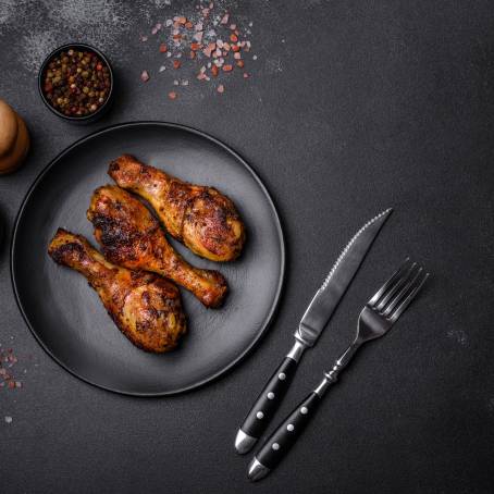 Flying BBQ Chicken Drumsticks with Spices and Vegetables, Spicy Grilled Legs Isolated