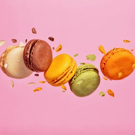 Freeze Motion of Colorful French Macarons Floating in Air on Blue Background