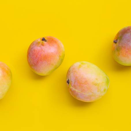 Fresh Yellow Mango Top Down View on Plain White Surface, Ideal for Fruit Photography