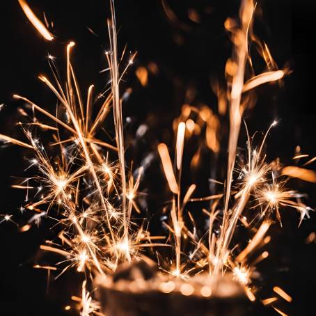 Glimmering Sparkler with Bright Sparks on Black Background  Close Up