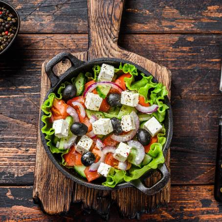 Greek Salad with Cheese and Fresh Vegetables Isolated on White Plate