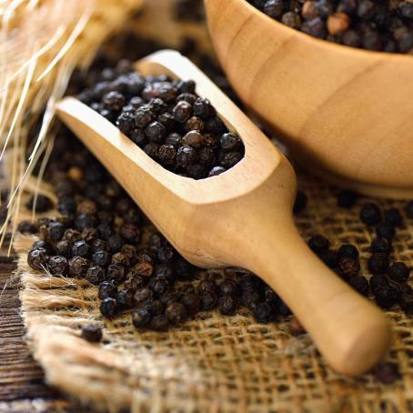 Ground Pepper and Peppercorns Close Up in Wooden Bowl