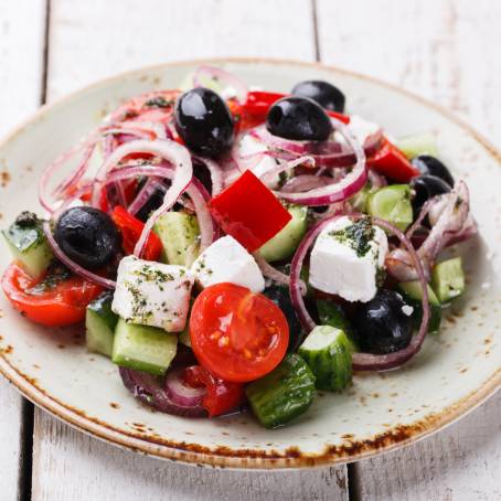 Healthy Greek Salad with Cheese and Fresh Veggies Isolated on White