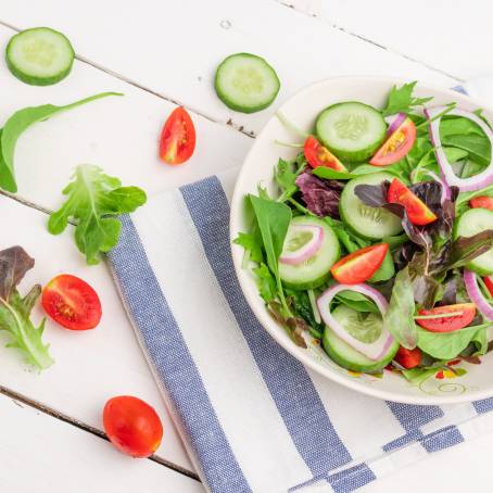 Healthy Salad with Spinach, Cherry Tomatoes, Lettuce, and Cucumber in Bowl, Isolated on White