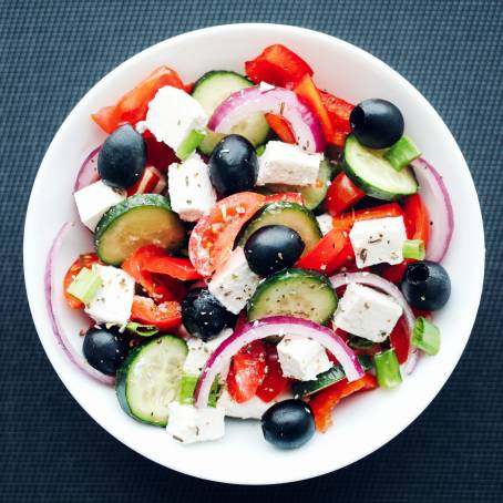 Isolated Greek Salad with Cheese and Fresh Vegetables on White