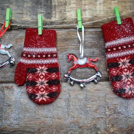 Isolated Pair of Red Knitted Mittens with Christmas Pattern on White Background