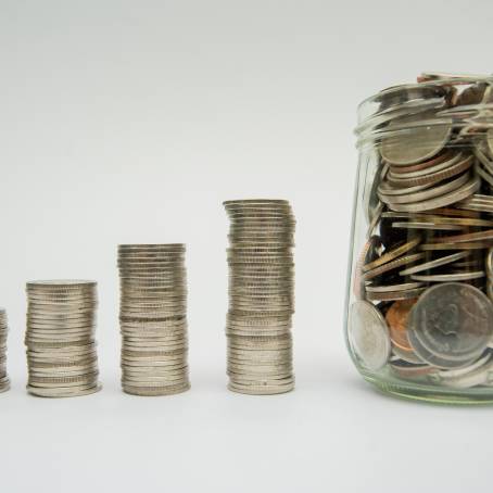 Jar with Money and Coin Stacks A Concept for Savings Growth and Financial Planning