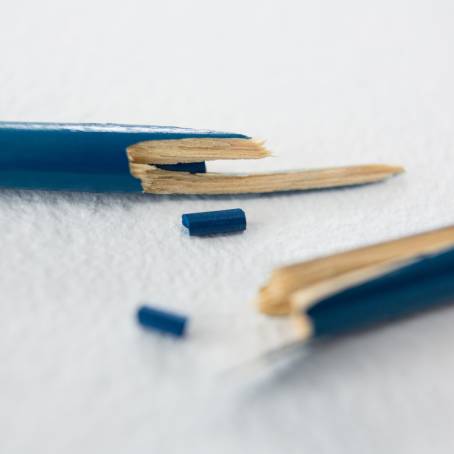 Macro Image of Broken Pencil Tip with Graphite on Red Background