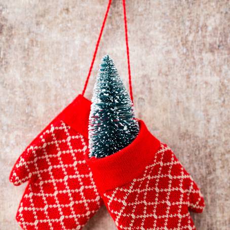 Pair of Festive Red Knitted Mittens with Christmas Pattern Isolated on White Background