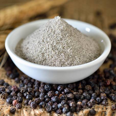 Peppercorns and Ground Pepper in Wooden Bowl Close Up