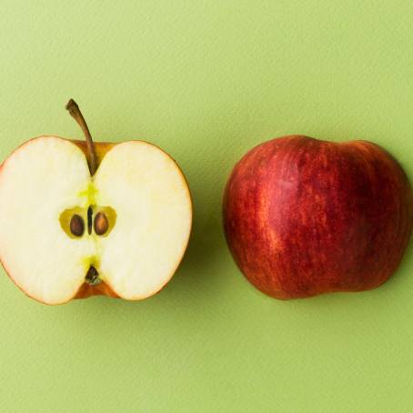 Red Apples with Slices in White Bowl on Black Background Top View