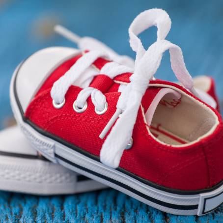 Red Retro Sneakers on Blue Wooden Backdrop Close Up Image of Fashionable Vintage Footwear