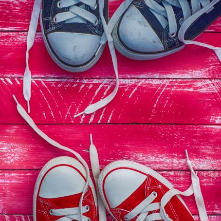 Red Retro Sneakers Placed on Blue Wooden Background Close Up of Vintage Footwear Design