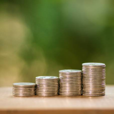 Savings Growth Insight Jar of Money and Coin Stacks for Financial Planning on Table