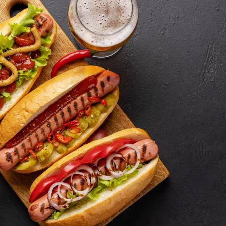 Savory Hot Dog with Mustard, Ketchup, and a Cold Beer at the Table