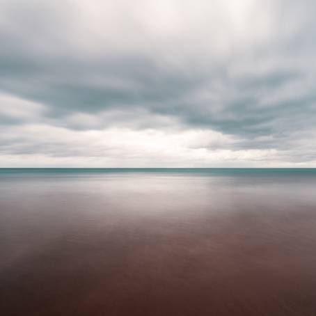 Serene Ocean with Clear Skies and Gentle Cloud Cover