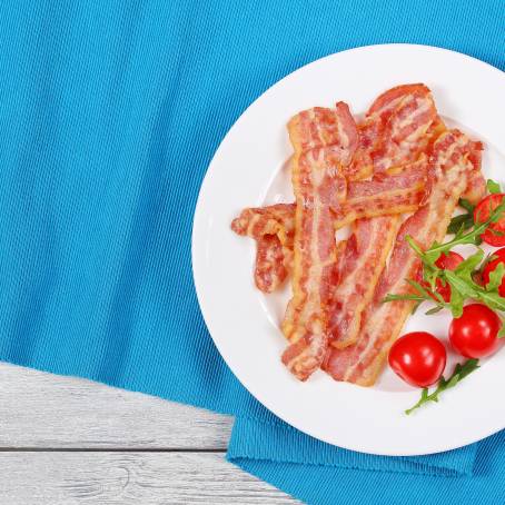 Single Crispy Bacon Slice on White Plate Isolated